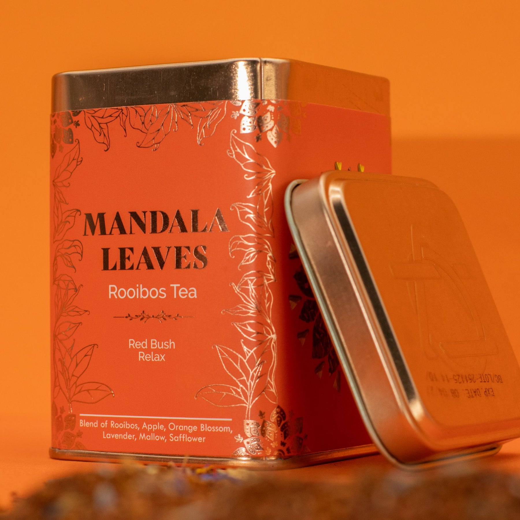 Mandala Leaves Rooibos Tea can with a gold lid on an orange background