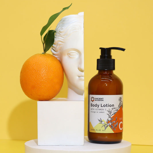 Amber pump bottle of Vitamin C Goddess’s Body Lotion with fresh orange