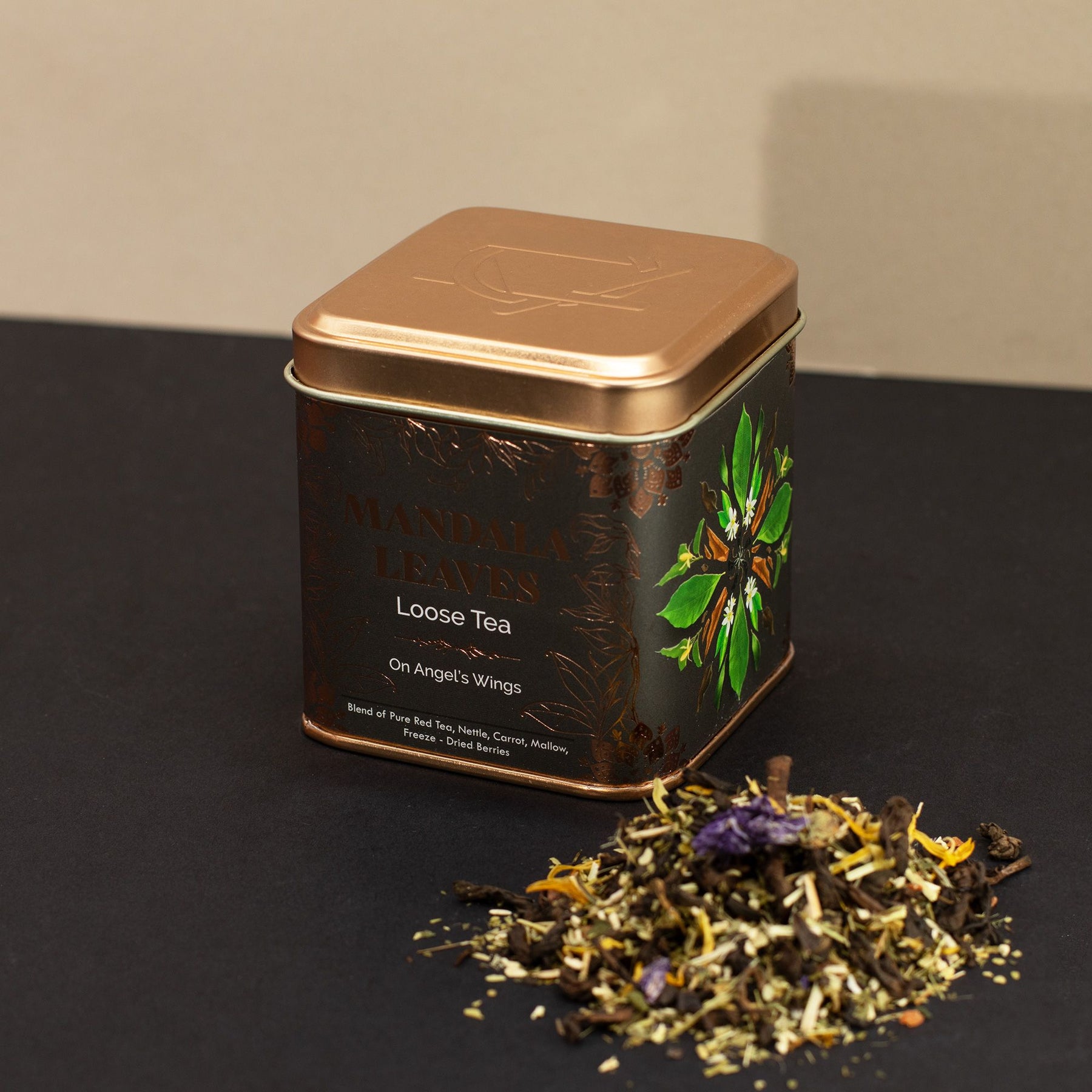 Tea tin with loose tea leaves on a dark surface