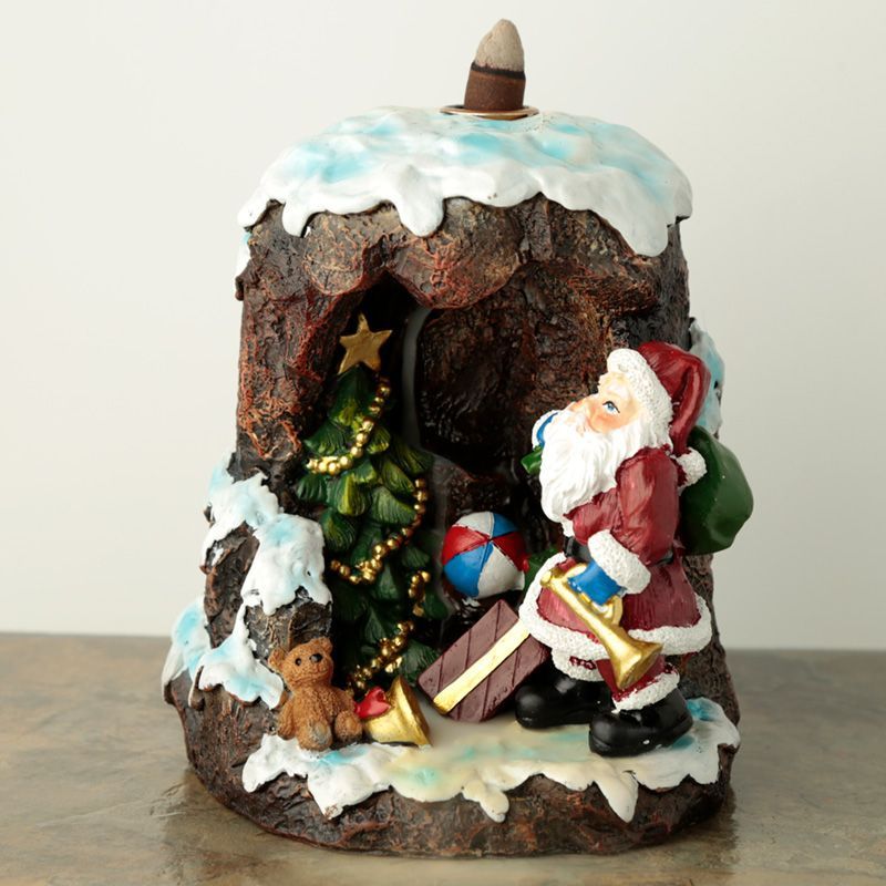 Santa’s Grotto backflow incense burner with glowing LED, smoke flowing down like waterfall, surrounded by cones and Christmas lights