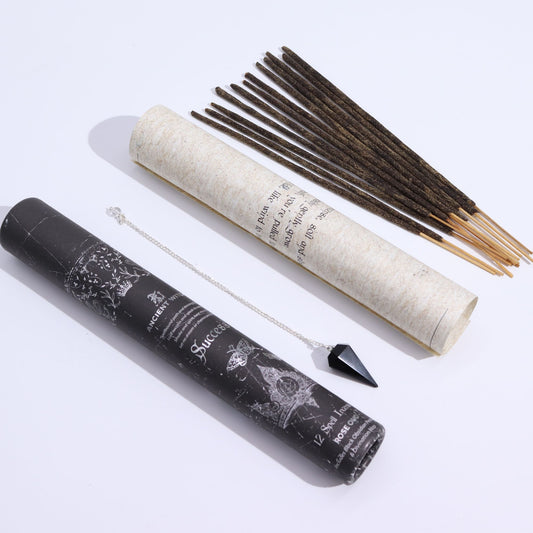 Incense sticks and pendulum with a black and a white cylindrical containers