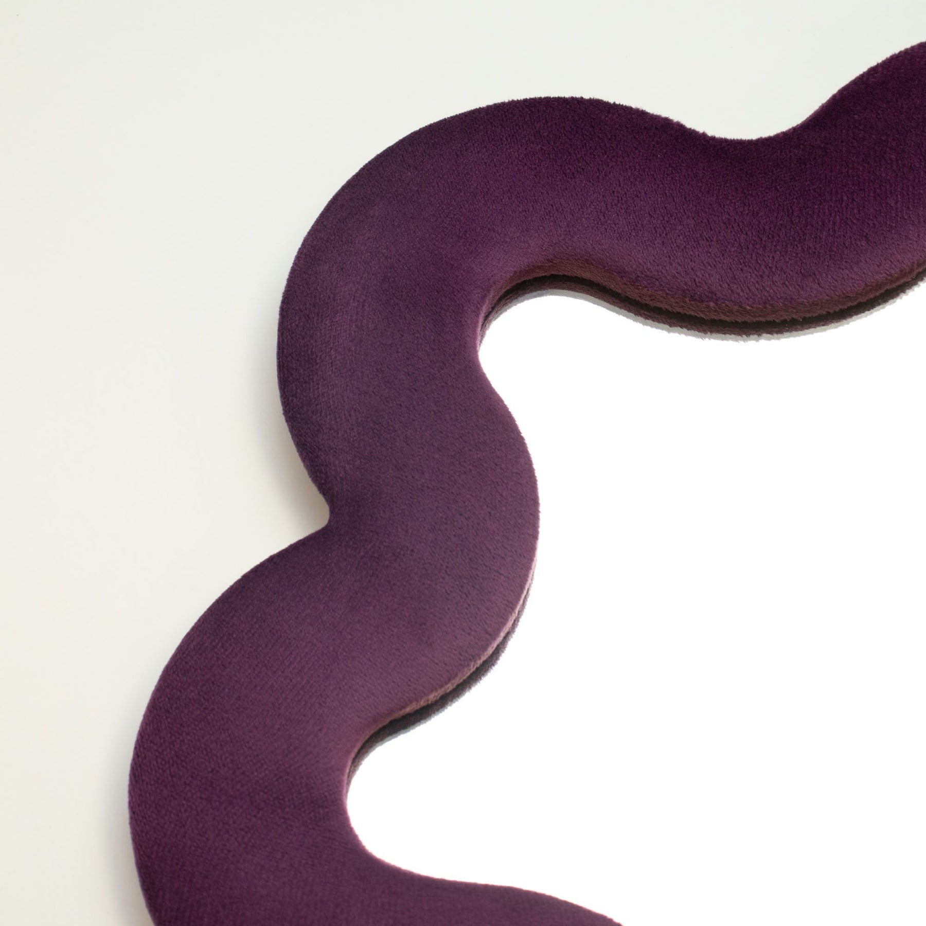 Close-up of mauve velvet texture on padded frame, showing plush finish and soft star-inspired squiggly edge detail