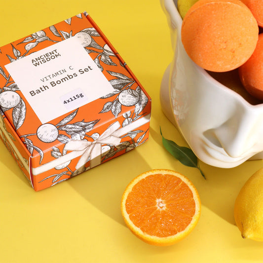 Box of Ancient Wisdom Vitamin C Bath Bombs Set with oranges on a yellow background