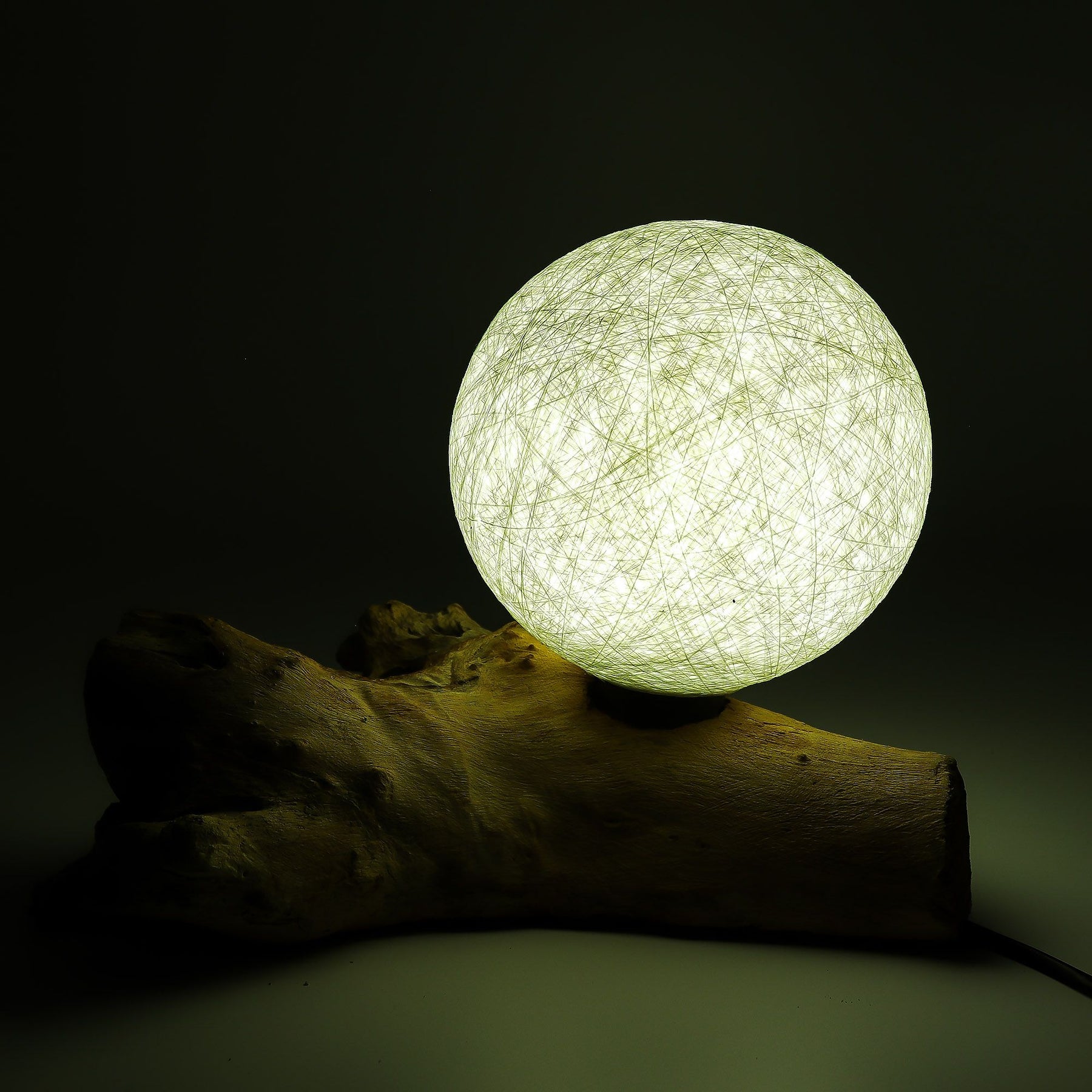 Ivory cotton-wrapped Luna sphere glowing like a full moon atop twisted driftwood base