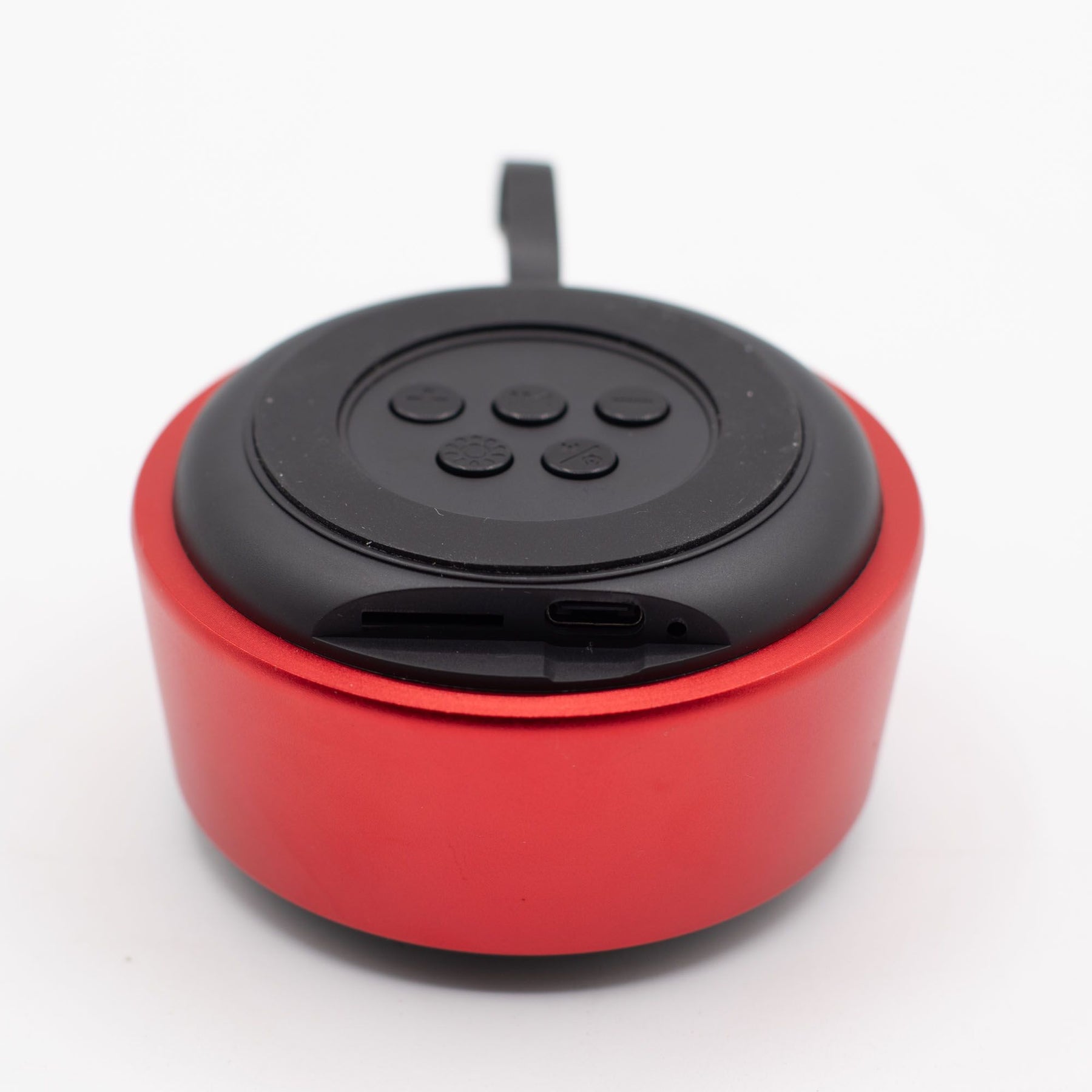 Close-up of red mini speaker showing mandala-style LED illumination pulsing in sync with music, speaker grille and top controls detail