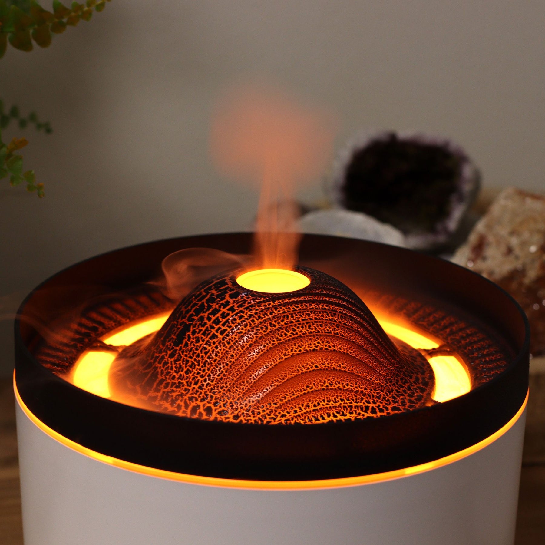 Large black volcano aroma diffuser erupting with swirling coloured mist and glowing LED ring