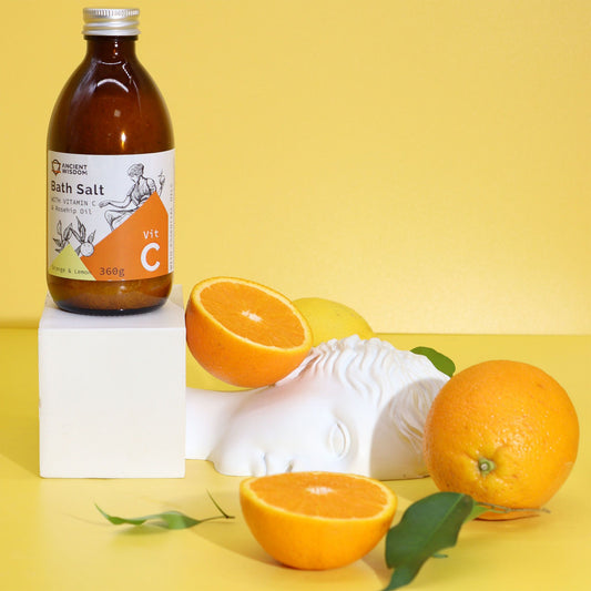 Bath salt bottle with oranges and lemons on a yellow background