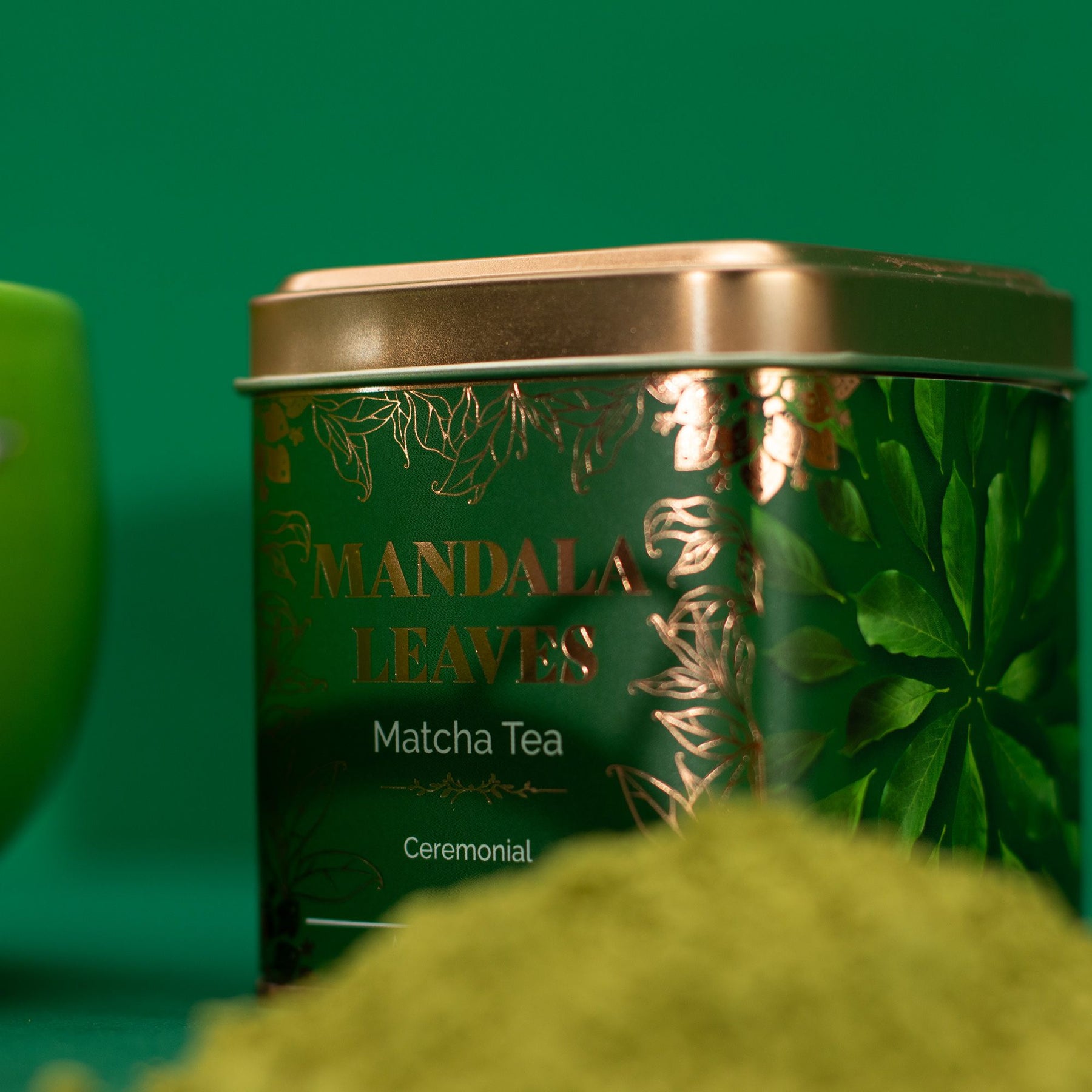 Green tea canister labeled 'Mandala Leaves Matcha Tea' with a green background