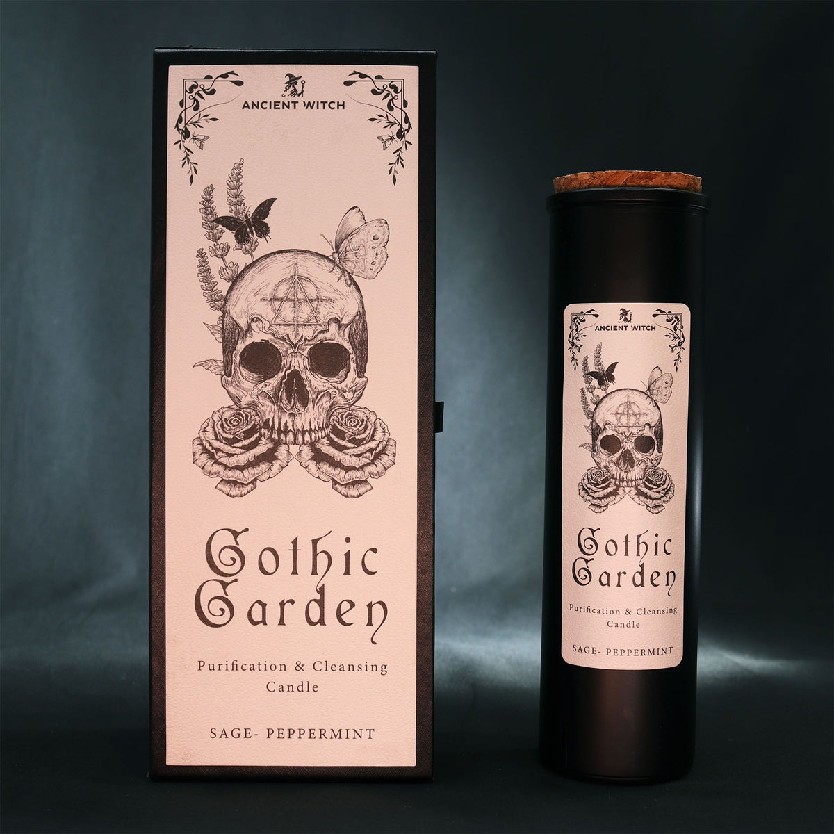 Black glass Gothic Garden candle burning with green flame, skull & roses label, surrounded by fresh sage nand peppermint leaves