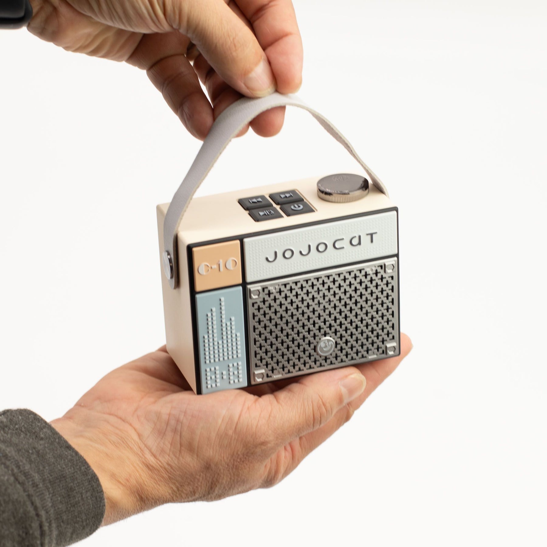 Hand holding a small vintage-style radio with 'JOJOCAT' branding on a white background