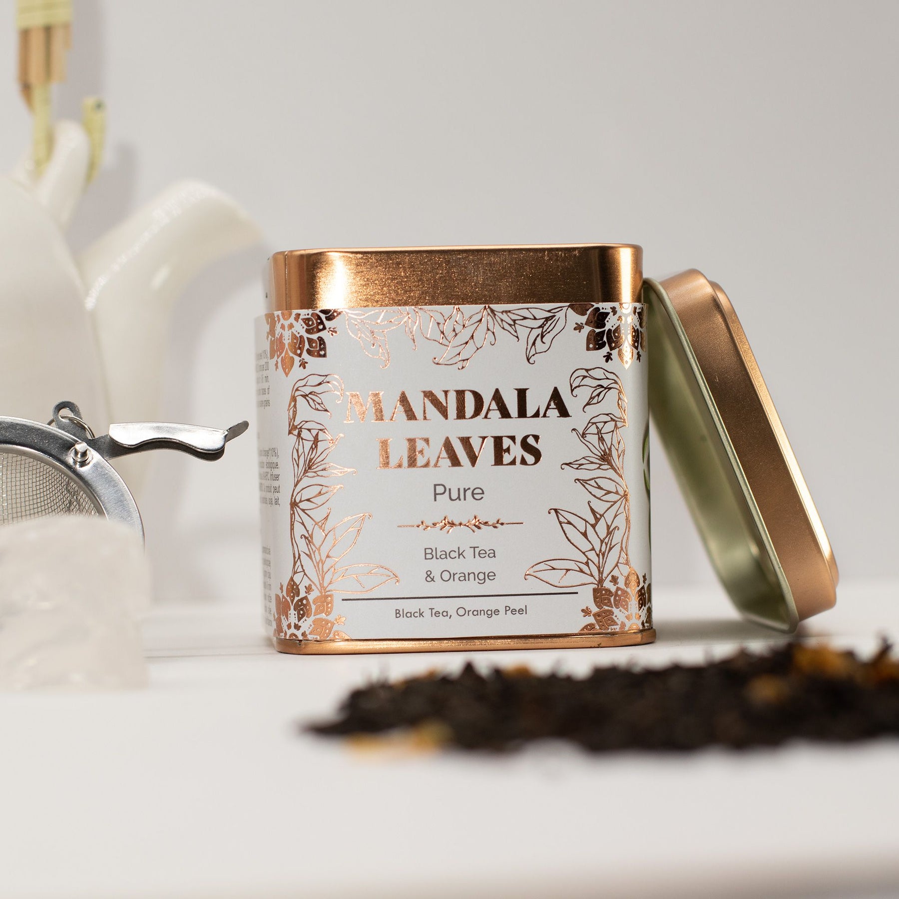 Mandala Leaves tea canister with loose tea leaves on a light background