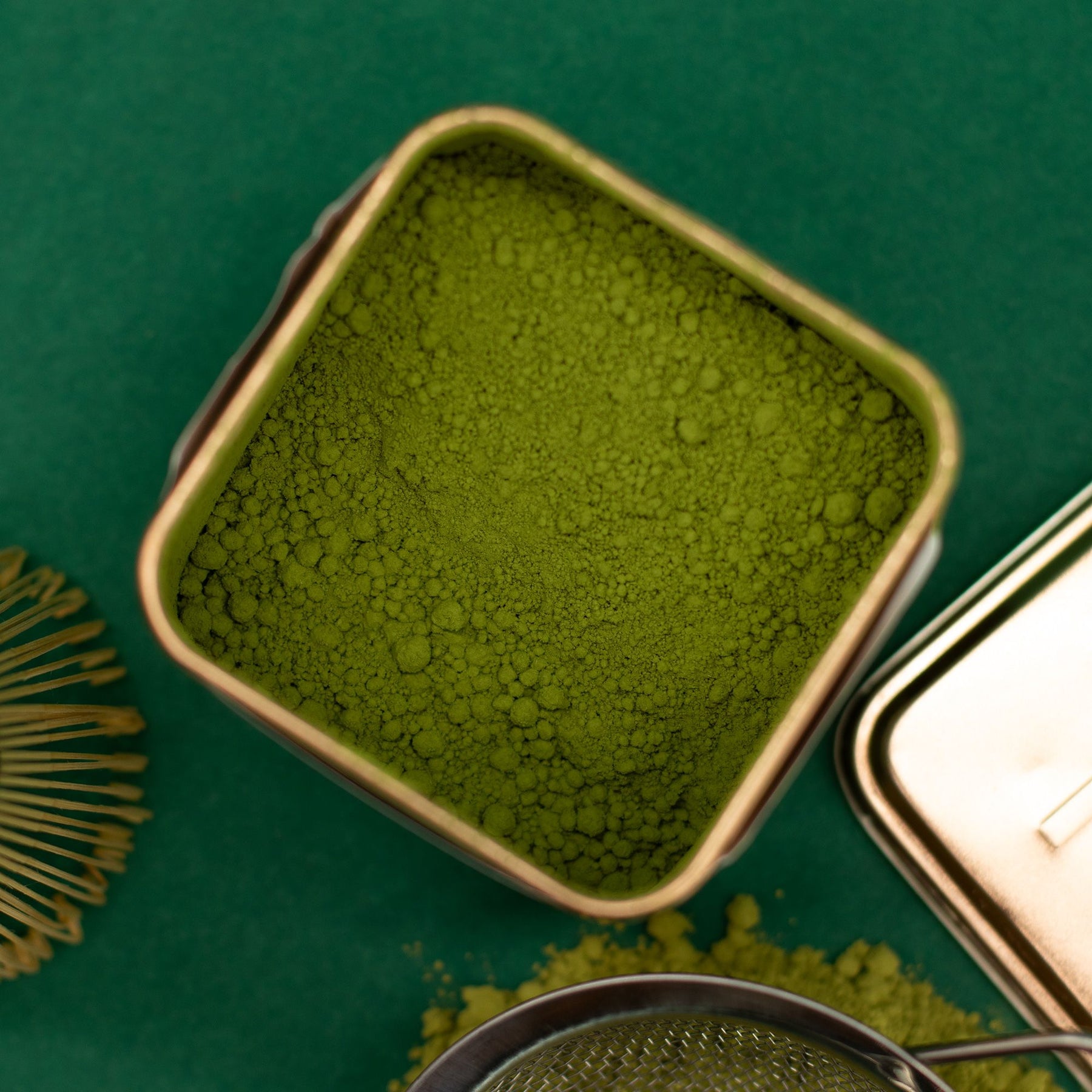 Green powder in a square container on a green background