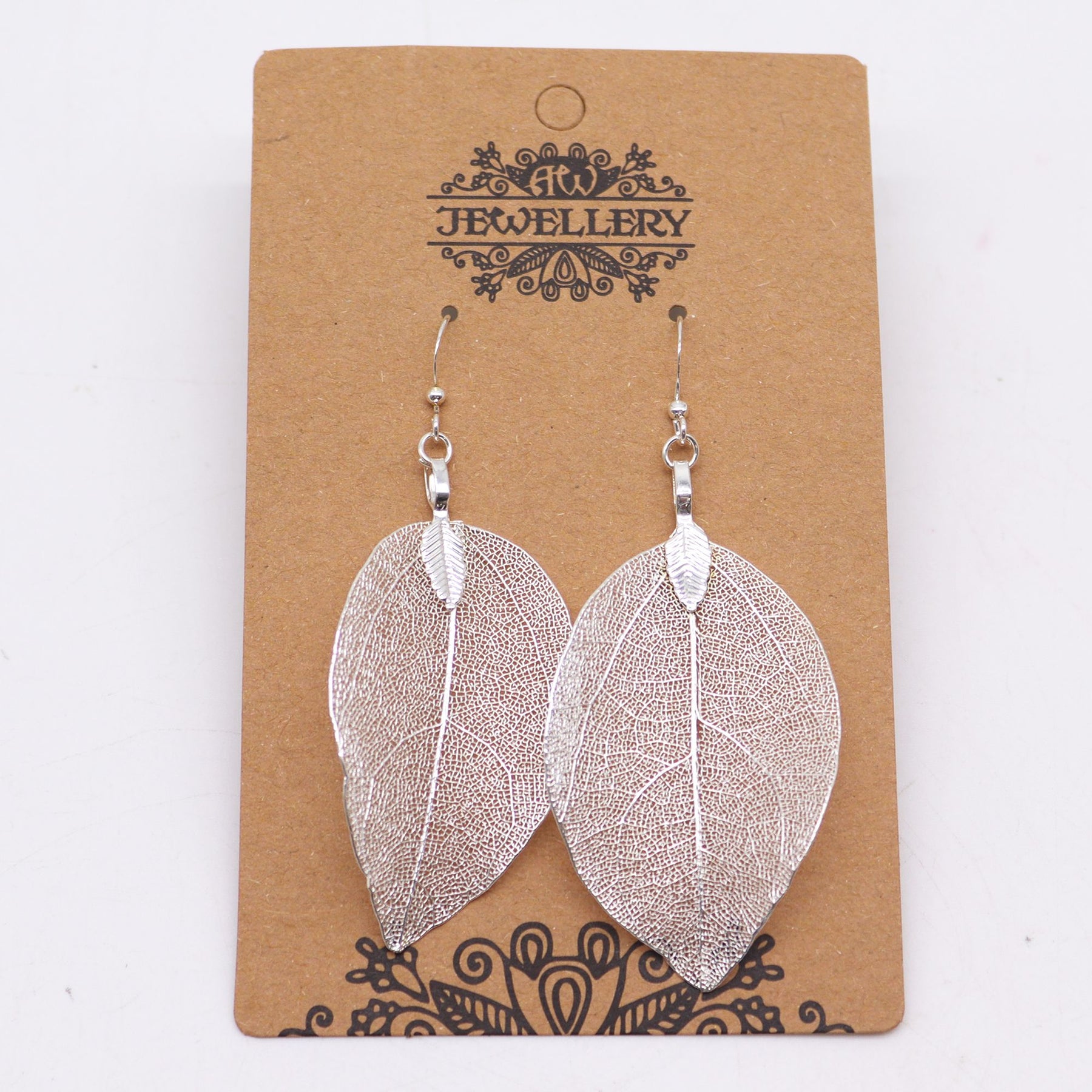 Silver leaf-shaped earrings on a brown jewelry card with decorative text.