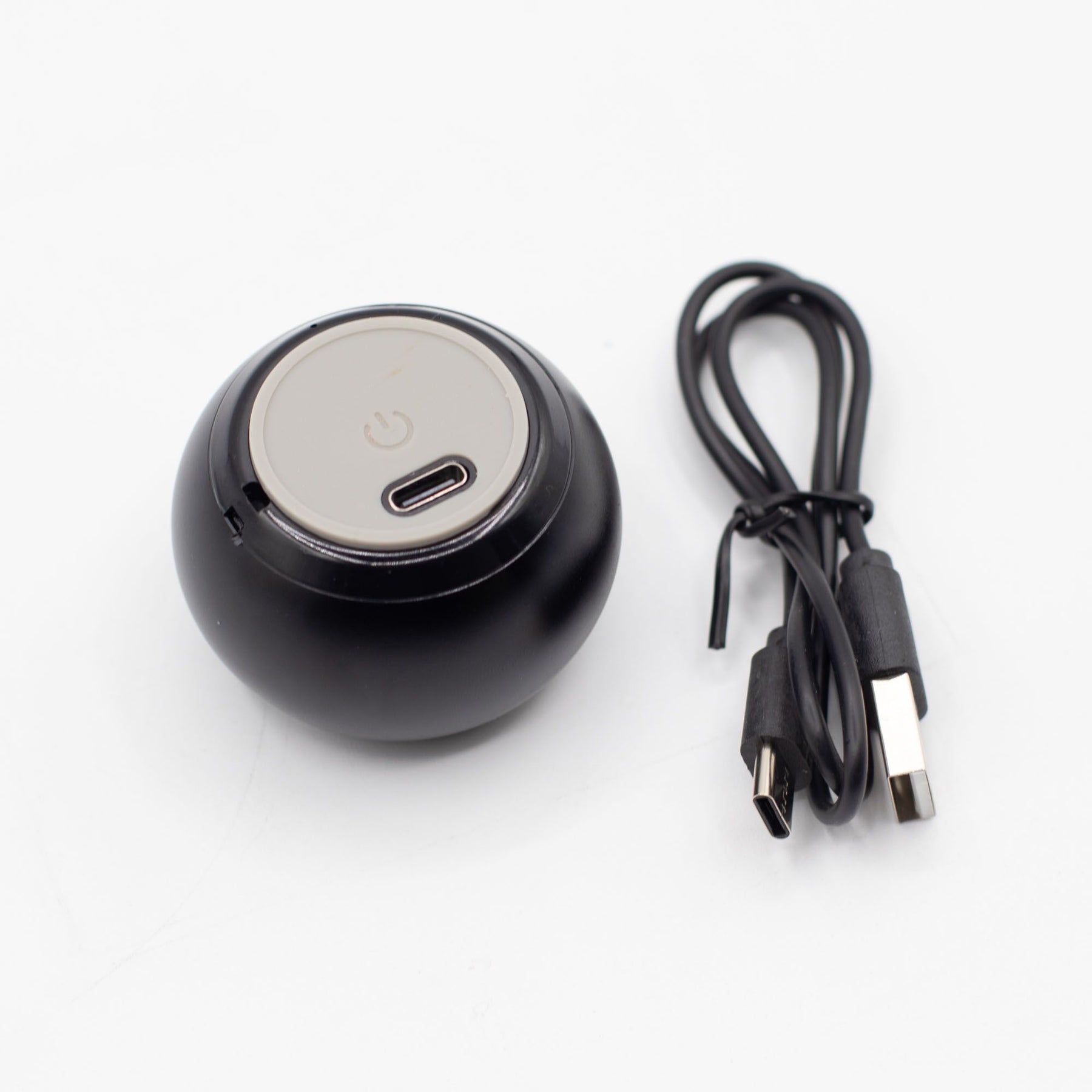 Speaker connected via USB charging cable, 300mAh battery indicator lit, compact size