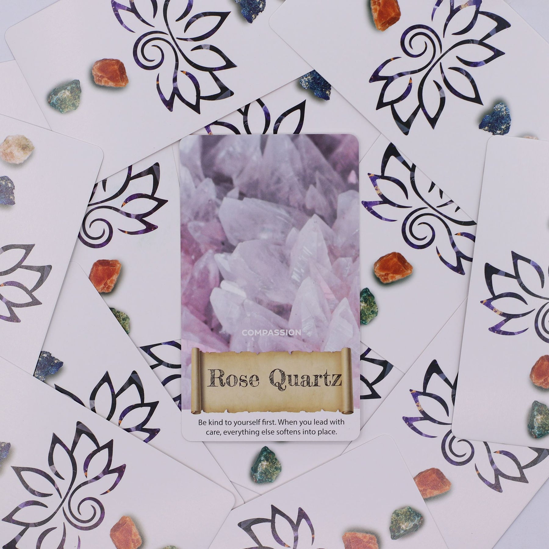 Crystals & Elixirs Oracle Deck fanned out showing colourful gemstone illustrations & elixir messages, box with radiant crystal design