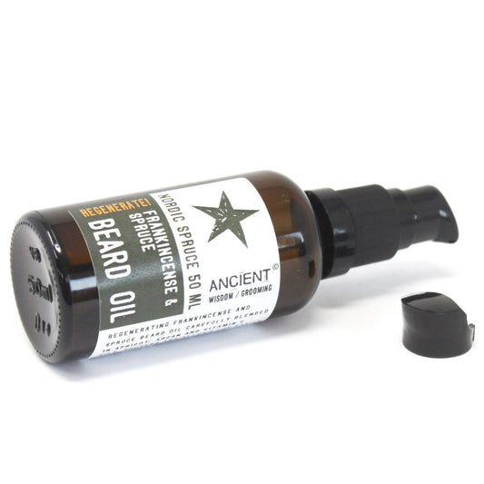 50ml amber glass bottle of Nordic Spruce Beard Oil with elegant dropper, surrounded by fresh spruce needles, frankincense resin and apricot kernels
