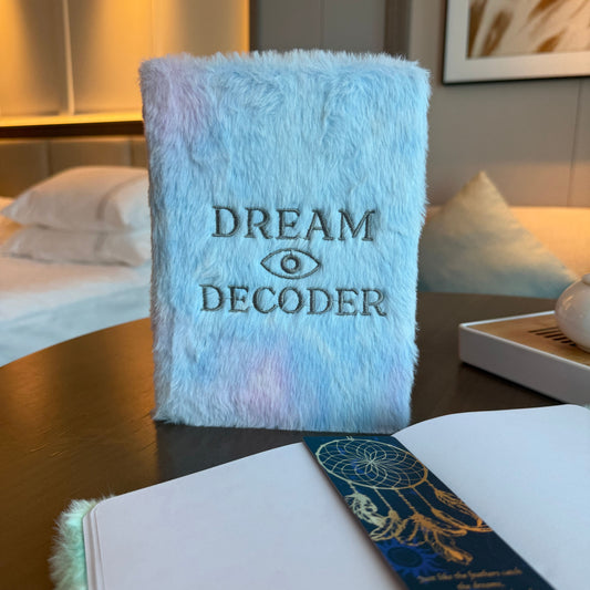 Fluffy blue pillow with 'Dream Decoder' text on a table in a bedroom setting