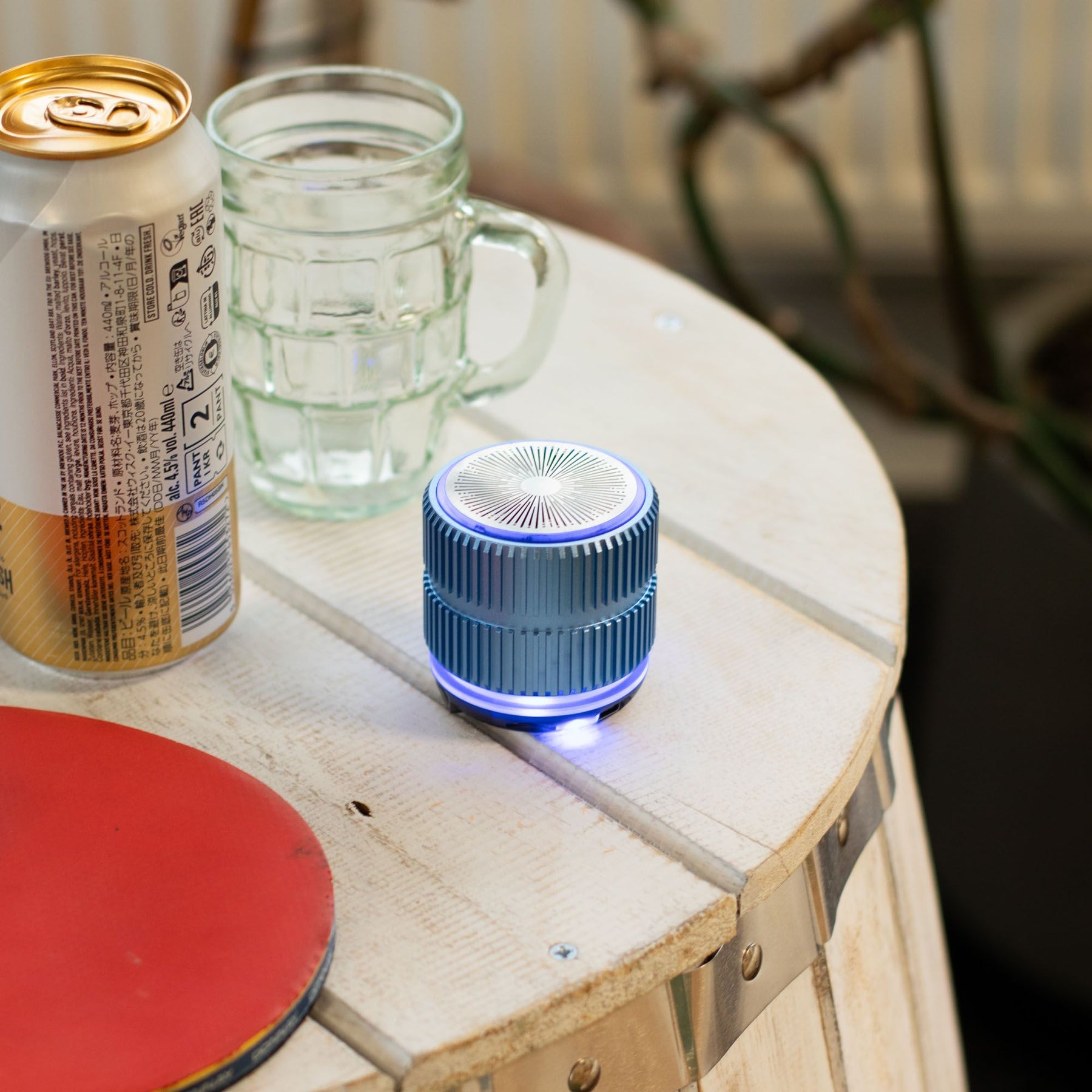 Mint Rock Mini Bluetooth Speaker in cool mint tone with textured rock-inspired metal-style body, compact size shown next to phone for scale, playing music with subtle LED glow