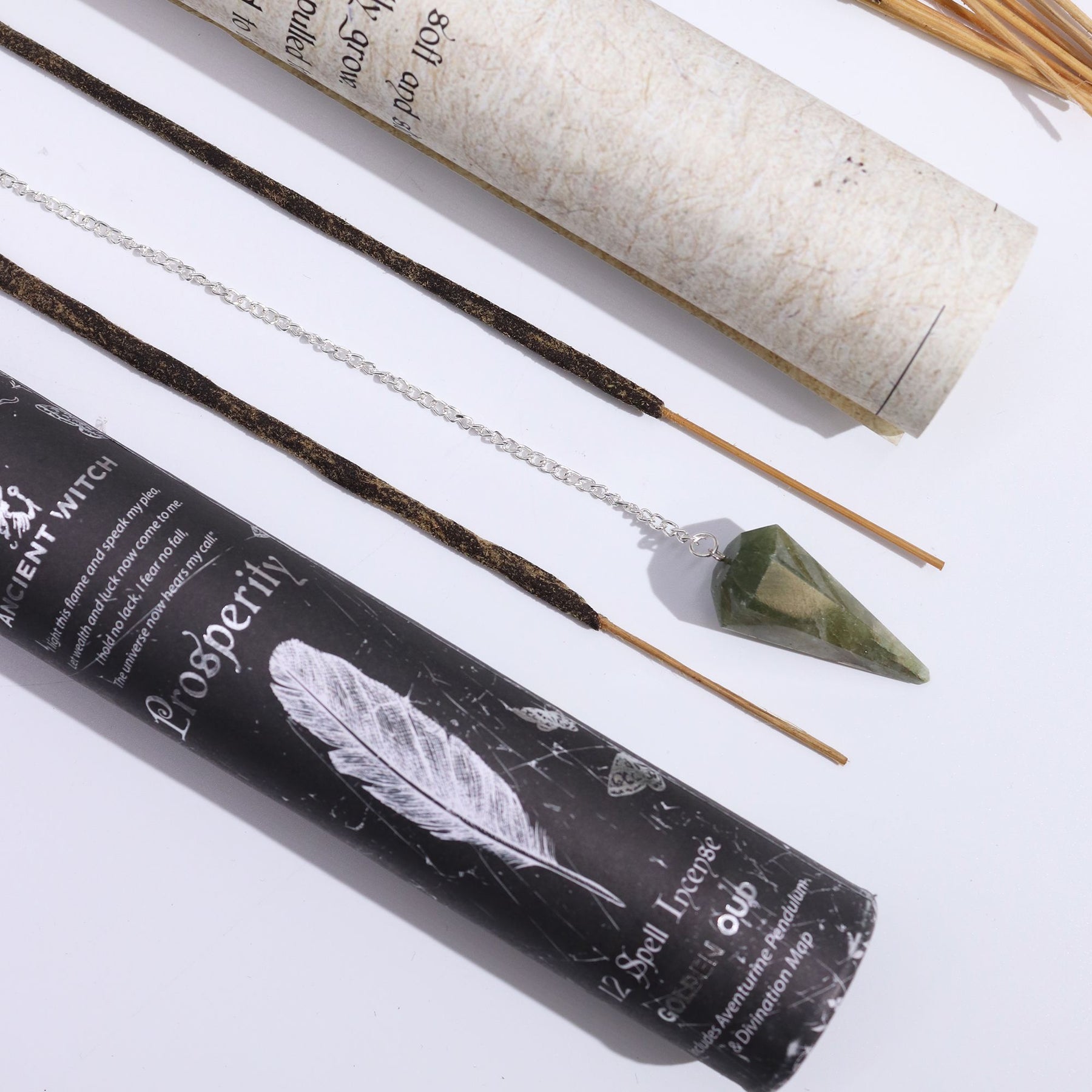 Incense sticks and pendulum with a black cylindrical packaging labeled 'Opulence' on a white background.