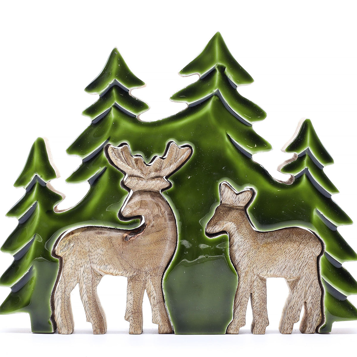 3D mango wood deer in forest decoration with two standing deer, green enamel trees and layered woodland scene on mantel with fairy lights and pine cones