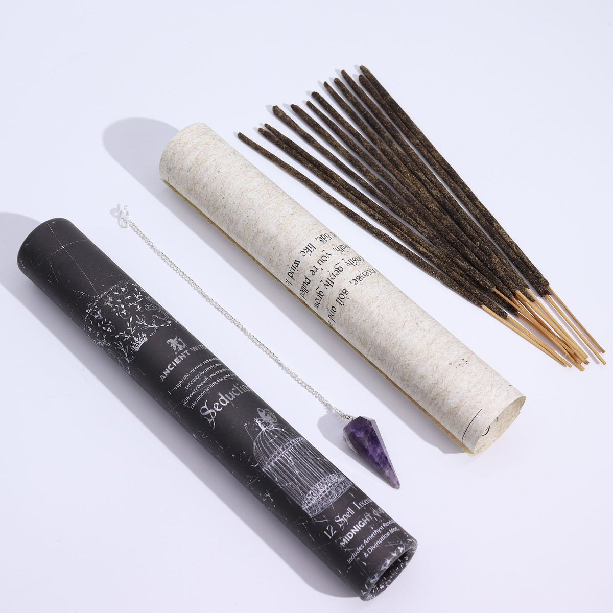 Incense sticks, roller, and pendulum amulet on a white background