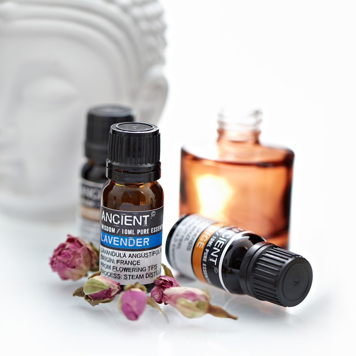 Bottle of Ancient Lavender essential oil with dried flowers on a white background