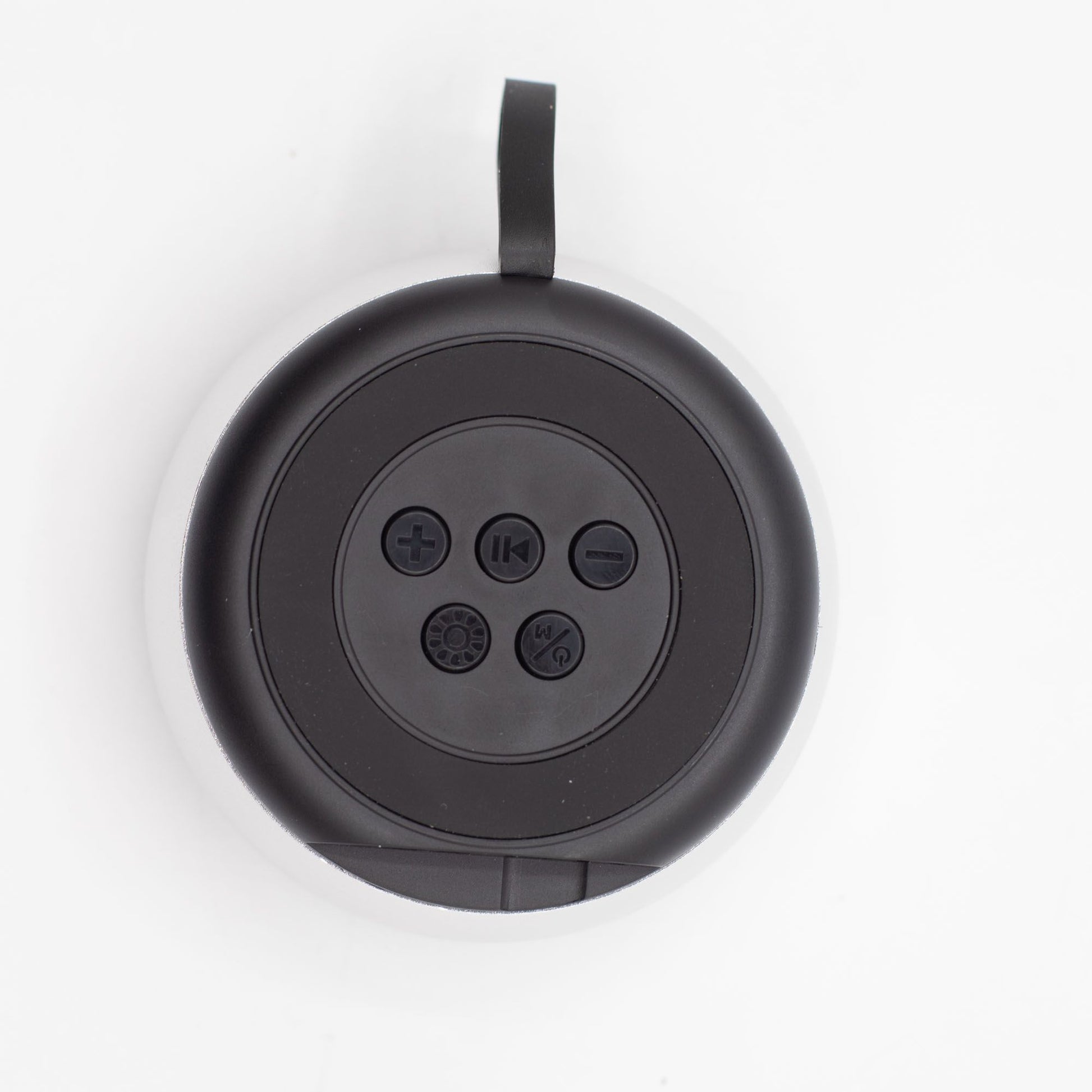 Close-up of silver mini speaker showing mandala-style LED illumination, top controls and speaker grille detail