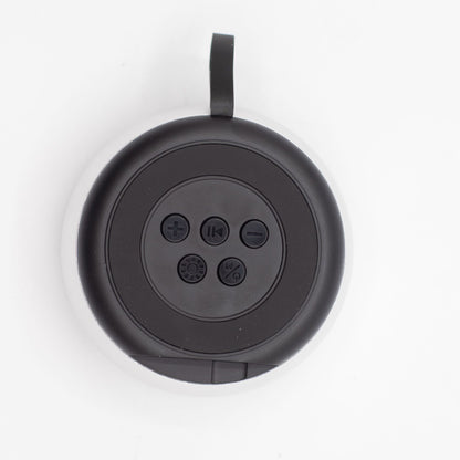 Close-up of silver mini speaker showing mandala-style LED illumination, top controls and speaker grille detail