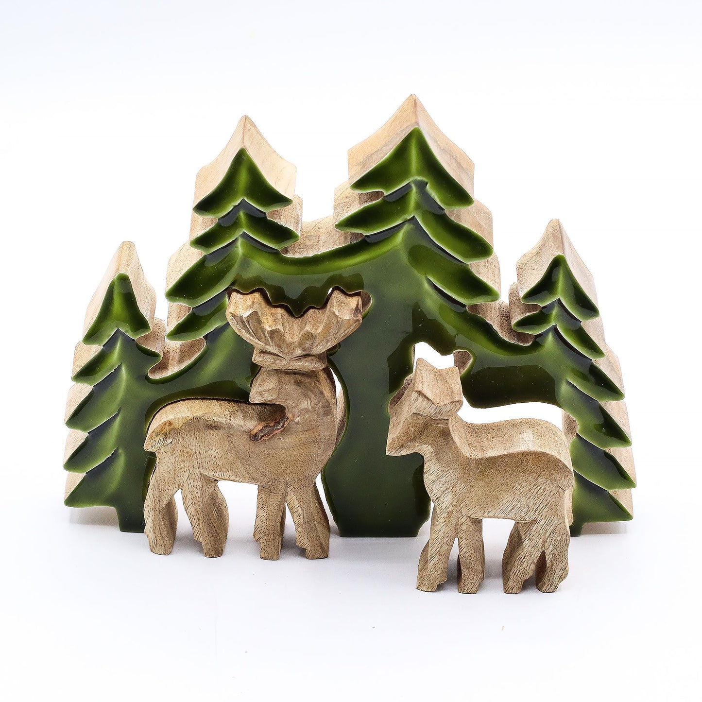 3D mango wood deer in forest decoration with two standing deer, green enamel trees and layered woodland scene on mantel with fairy lights and pine cones