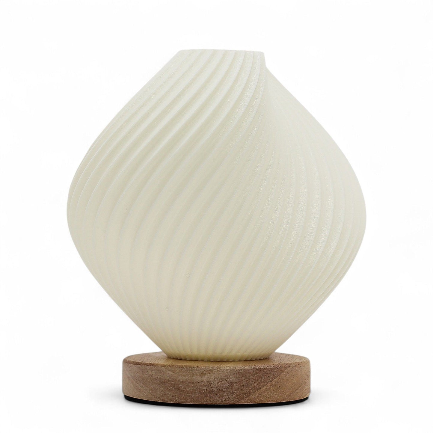 Shell Twisted New Wave USB lamp with textured honeycomb surface and elegant twisted shell-inspired shape, warm glow on 3rd brightness setting, placed on wooden base
