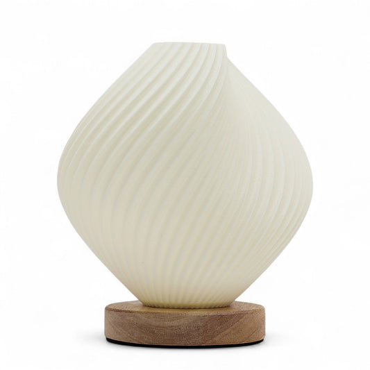 Shell Twisted New Wave USB lamp with textured honeycomb surface and elegant twisted shell-inspired shape, warm glow on 3rd brightness setting, placed on wooden base