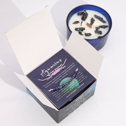 A candle with dried herbs in a blue container next to its packaging