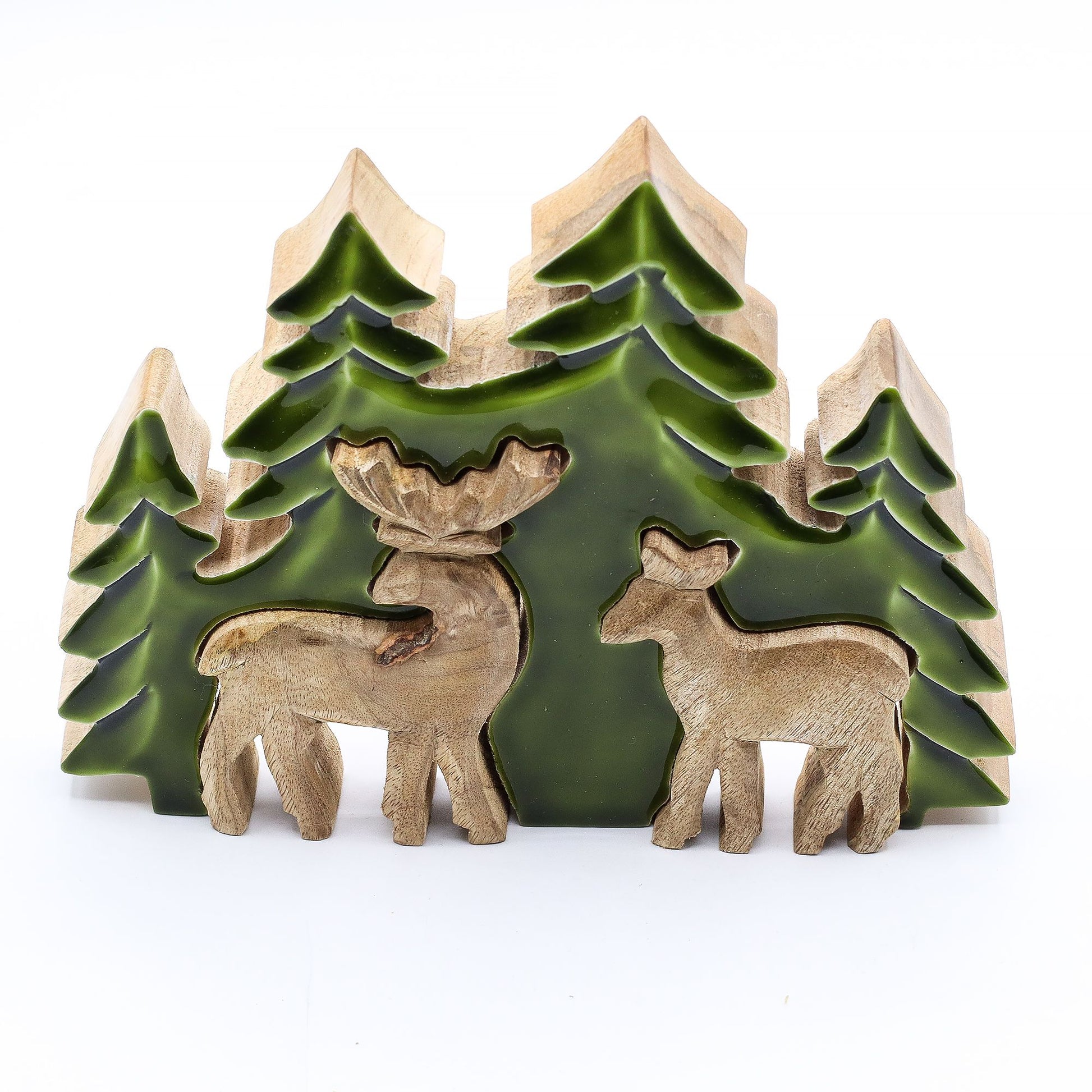 3D mango wood deer in forest decoration with two standing deer, green enamel trees and layered woodland scene on mantel with fairy lights and pine cones