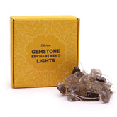 Citrine Gemstone Enchantment Lights with warm golden-yellow glowing bulbs on 227cm string, draped decoratively around crystals and plants, creating uplifting ambient light