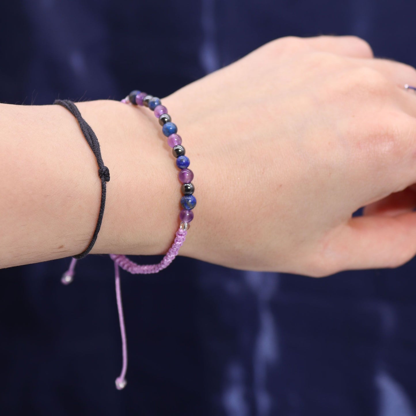 Close-up of a wrist wearing two beaded bracelets