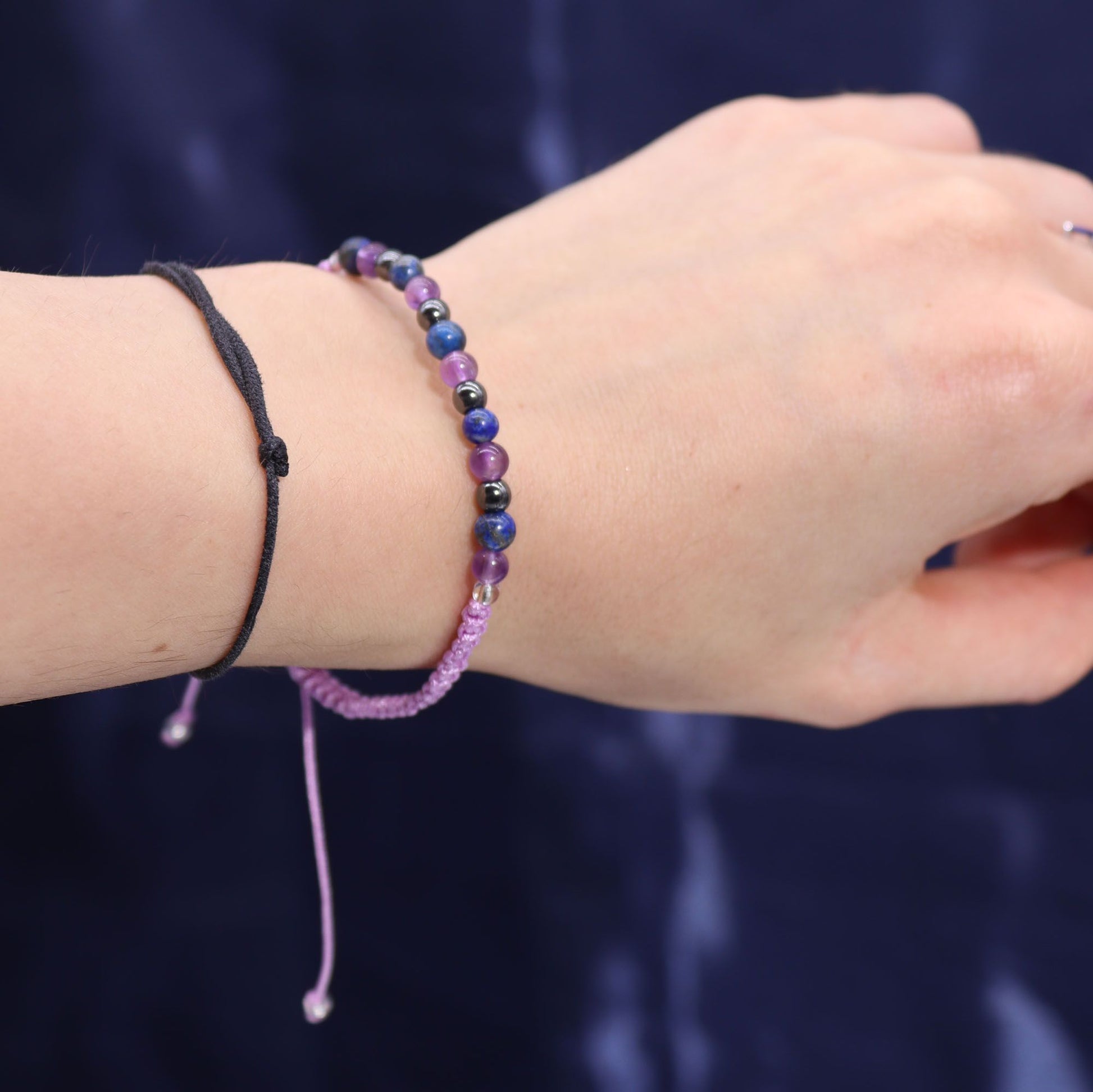 Close-up of a wrist wearing two beaded bracelets