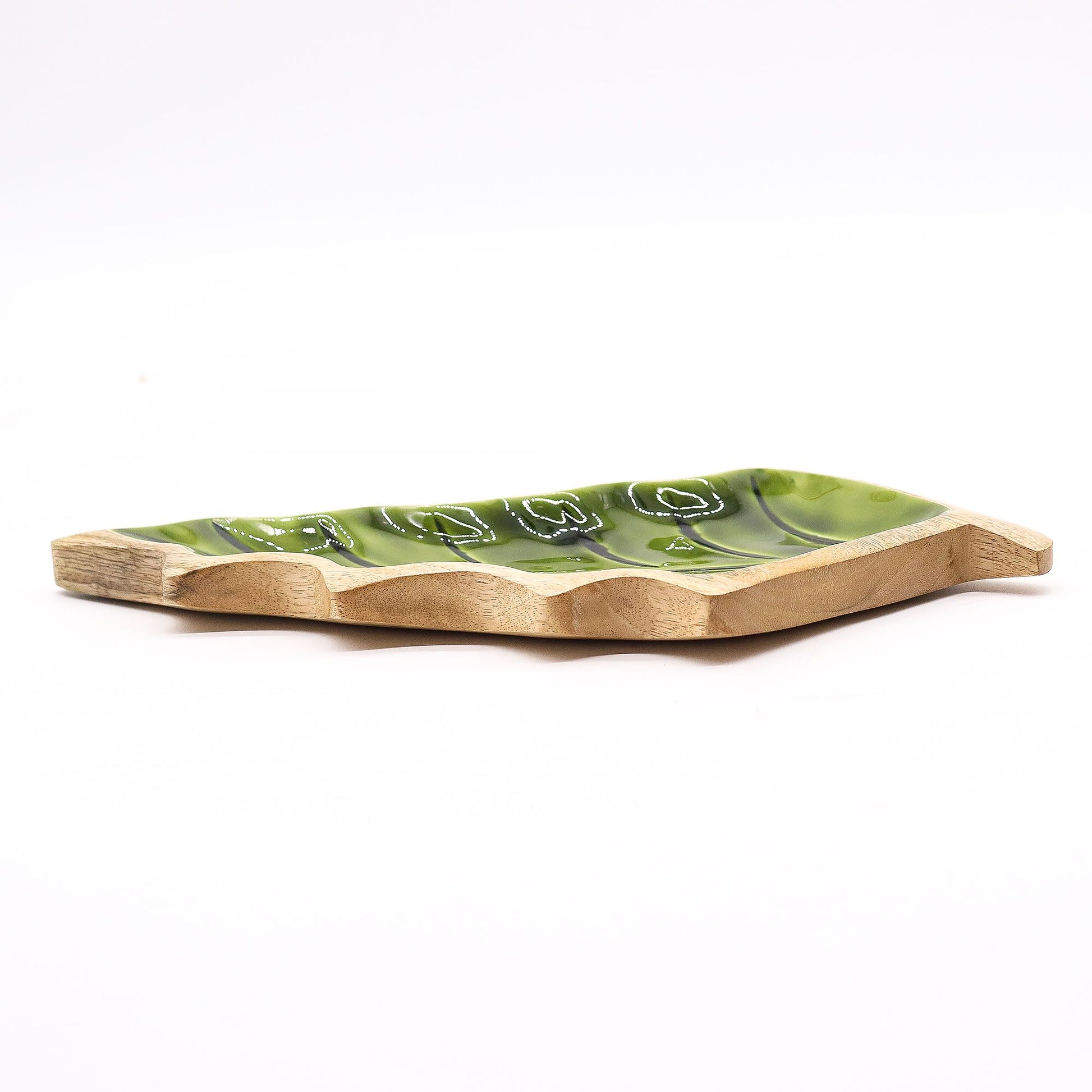 Large leaf-shaped mango wood bowl with rich green enamel inside, filled with pine cones and candles on autumn table setting