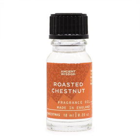 10ml amber glass bottle of Roasted Chestnut fragrance oil with chestnuts and glowing fireplace in cosy winter background