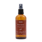 100ml Warm Gingerbread room spray bottle with gingerbread men, cinnamon sticks and orange slices on cosy Christmas kitchen background