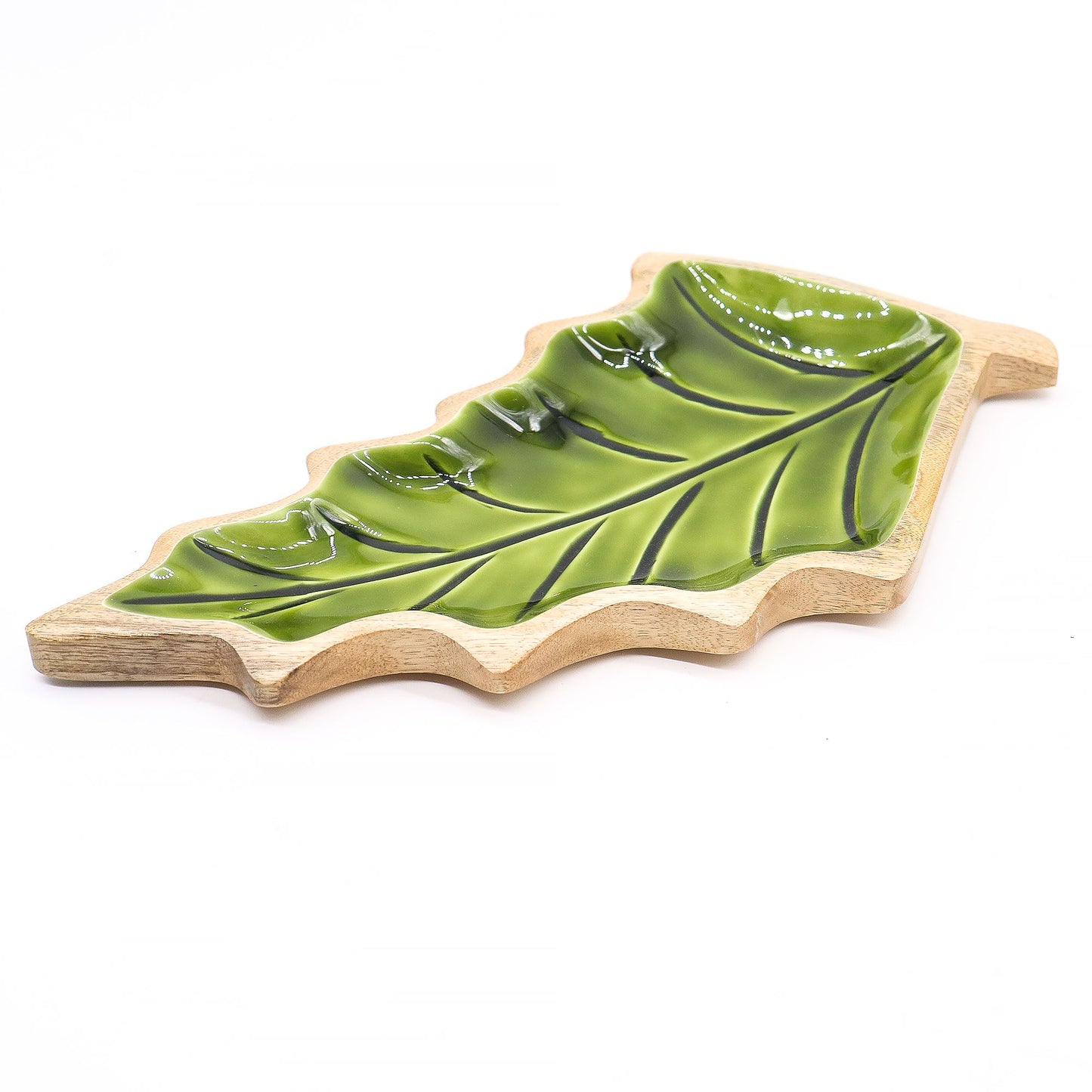 Large leaf-shaped mango wood bowl with rich green enamel inside, filled with pine cones and candles on autumn table setting