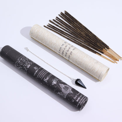 Incense sticks and pendulum with a black and a white cylindrical containers