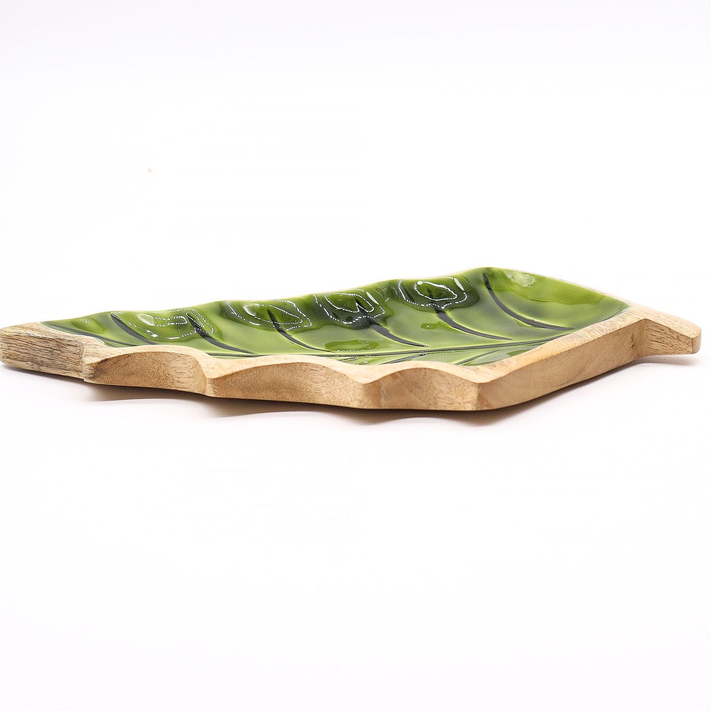Large leaf-shaped mango wood bowl with rich green enamel inside, filled with pine cones and candles on autumn table setting