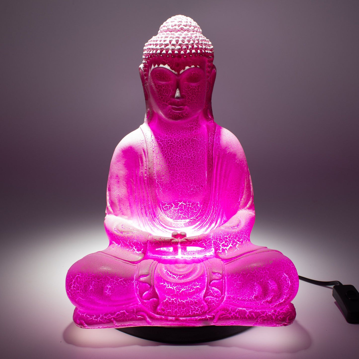 Meditation Buddha Lamp with crackle textured surface on modern oval stand, emitting soft warm ambient glow in a calm living space with subtle lighting