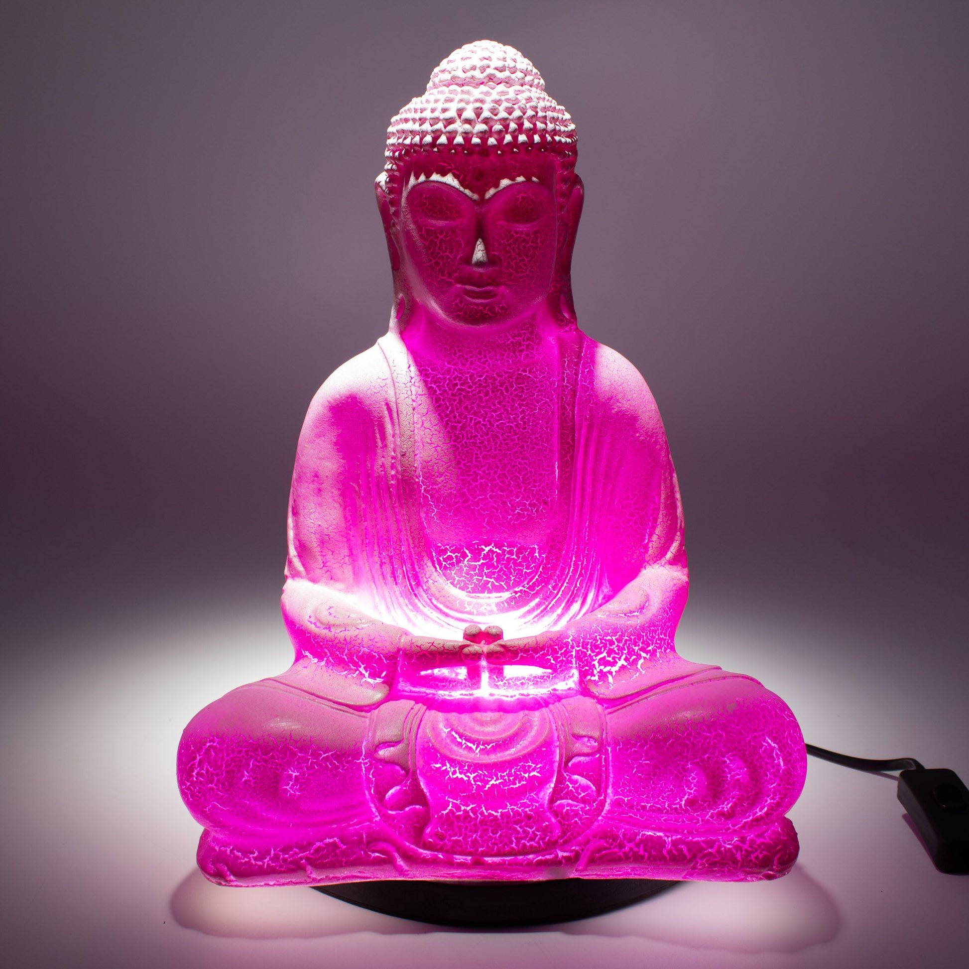 Meditation Buddha Lamp with crackle textured surface on modern oval stand, emitting soft warm ambient glow in a calm living space with subtle lighting