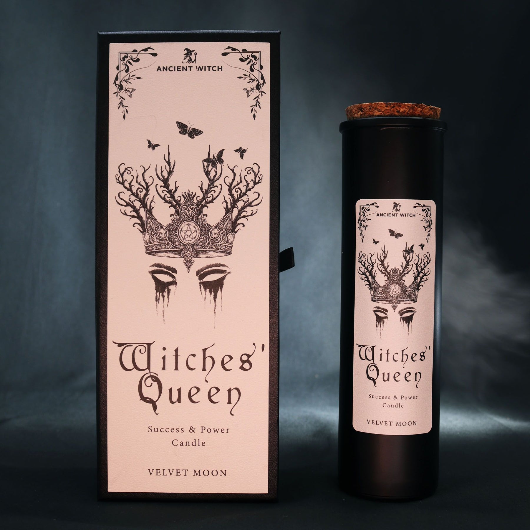 Witches' Queen candle packaging with pink box and black candle against a dark background