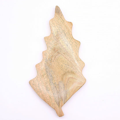 Large leaf-shaped mango wood bowl with rich green enamel inside, filled with pine cones and candles on autumn table setting