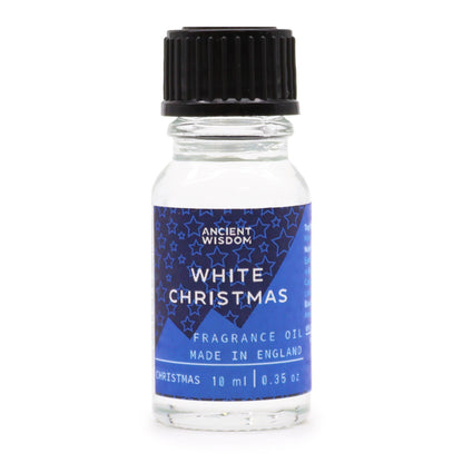 10ml White Christmas fragrance oil bottle surrounded by frosted pine, snowflakes and glittering snow on dark winter background