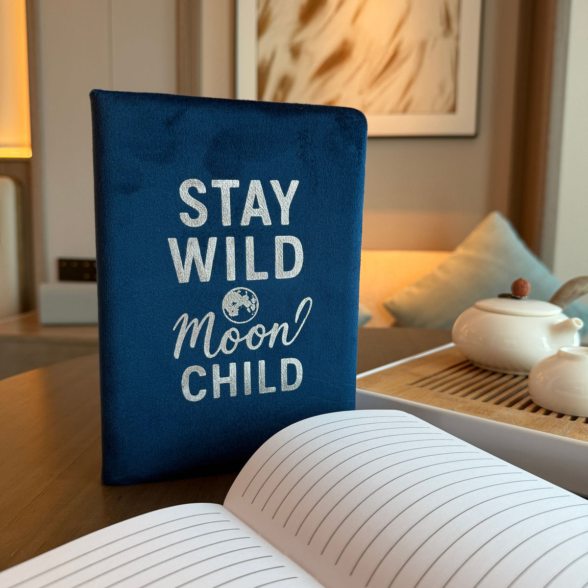 Deep blue velvet notebook with glowing silver “Stay Wild Moon Child” script