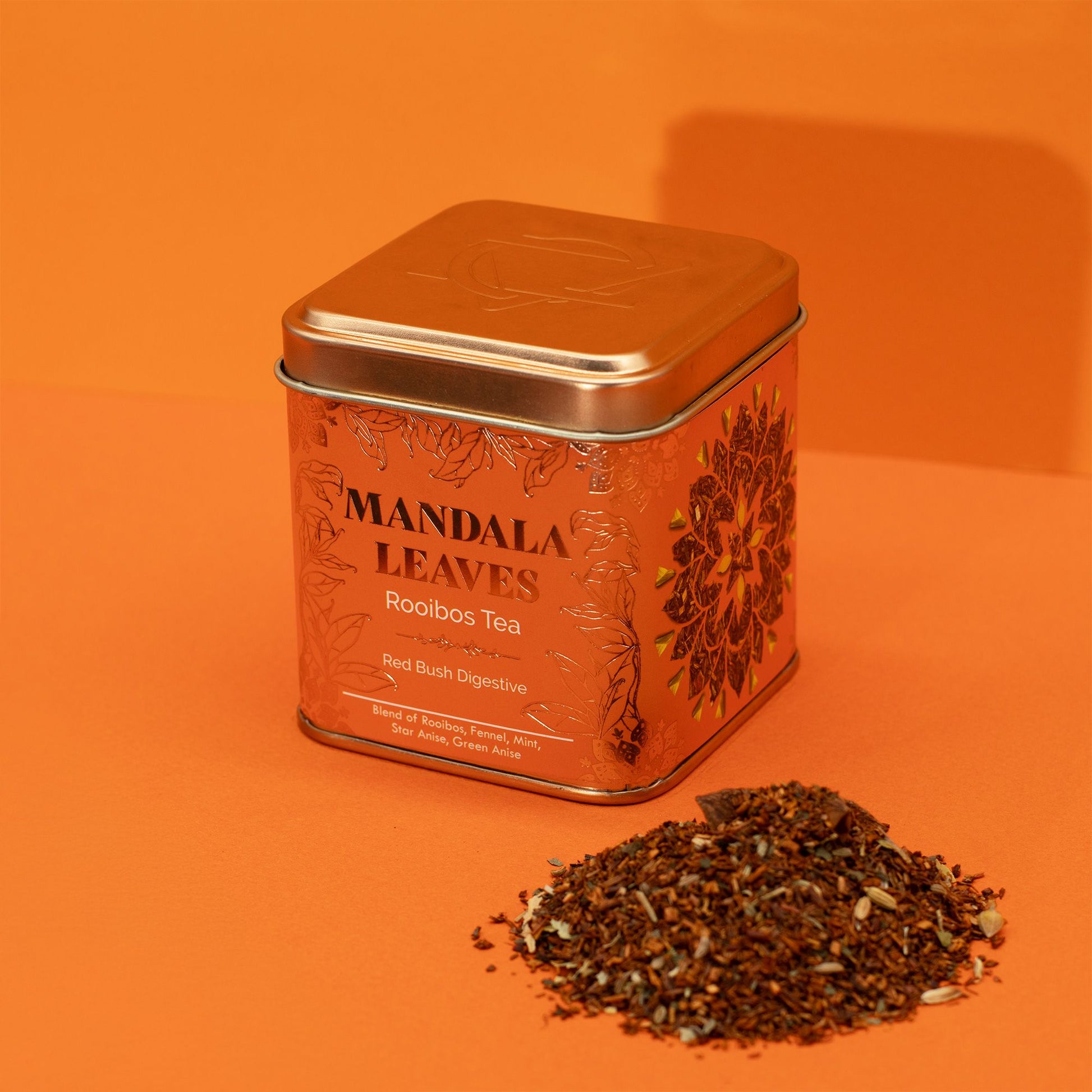 Mandala Leaves Rooibos Tea tin with loose tea on an orange background