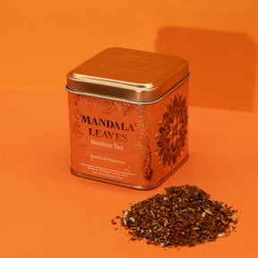 Mandala Leaves Rooibos Tea tin with loose tea on an orange background